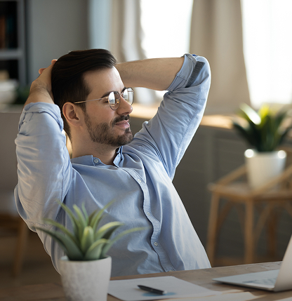 Άντρας κάθεται χαλαρός μπροστά σε laptop