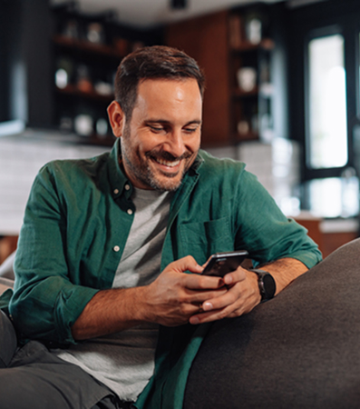 Άντρας που κοιτάει κάτι στο κινητό του και χαμογελάει
