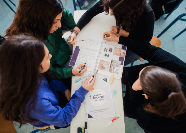 Μαθητές σε θρανίο με τα βιβλία της κυκλικη΄ς οικονομίας